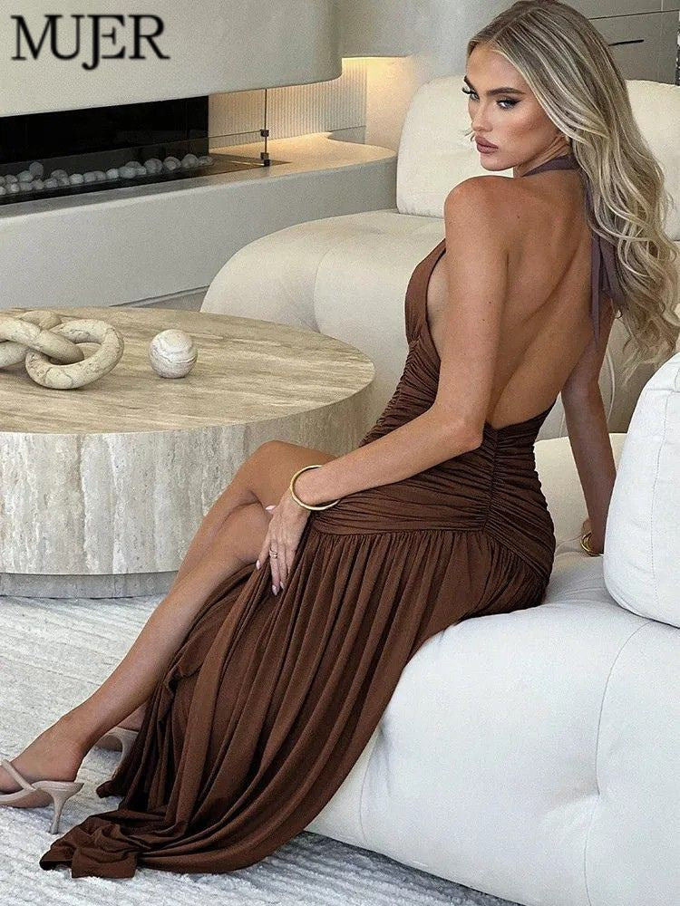 Woman in a brown dress sitting on a white couch in a stylish room.