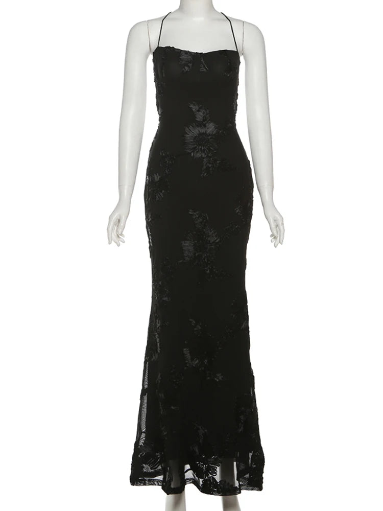 Woman wearing a floral lace evening gown on a black background