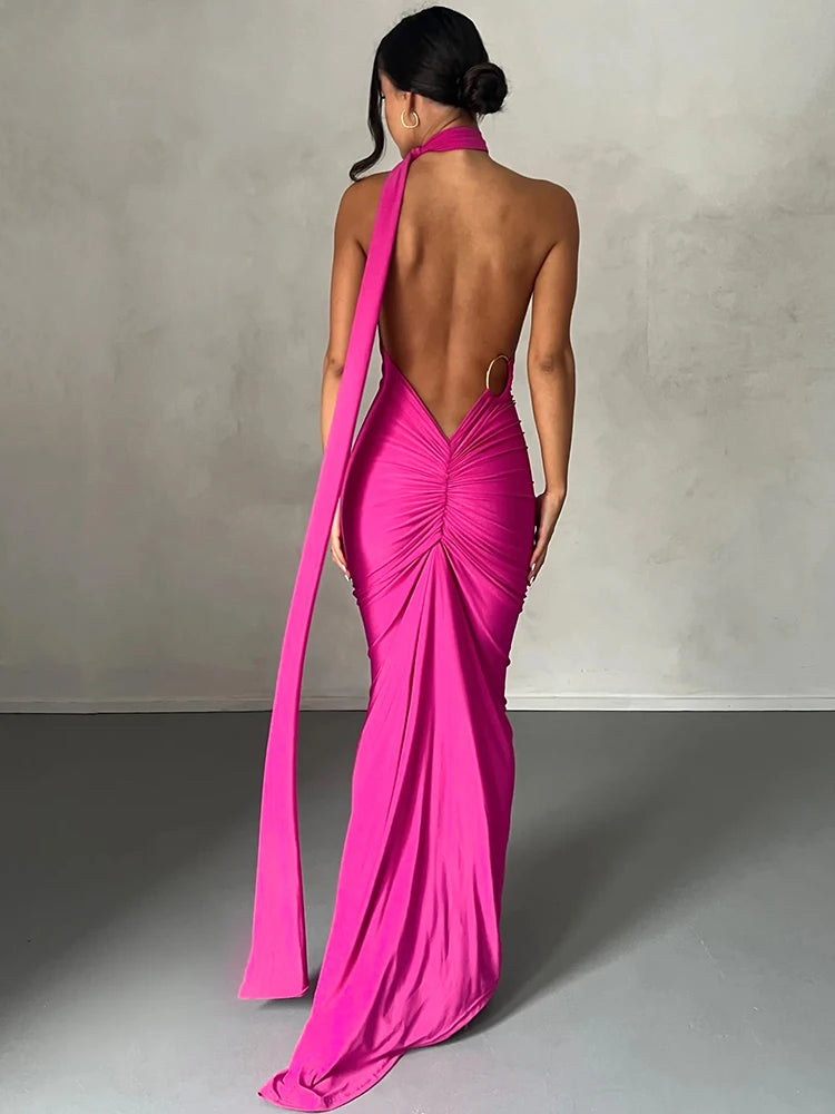 Woman wearing a pink evening gown with a long train against a neutral background