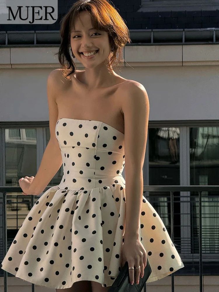 Woman wearing a strapless polka dot dress in an outdoor setting with 'MUJER' branding.